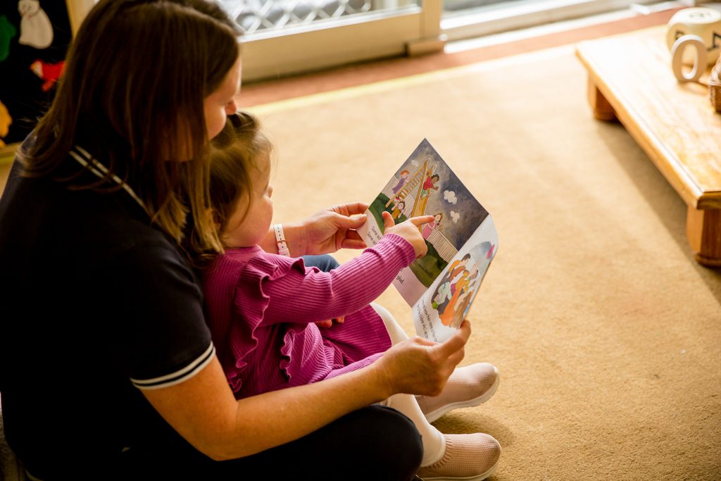 Teacher and little girl reading